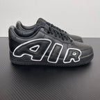 Black low-top sneakers with white flame-style logo overlays and black laces.