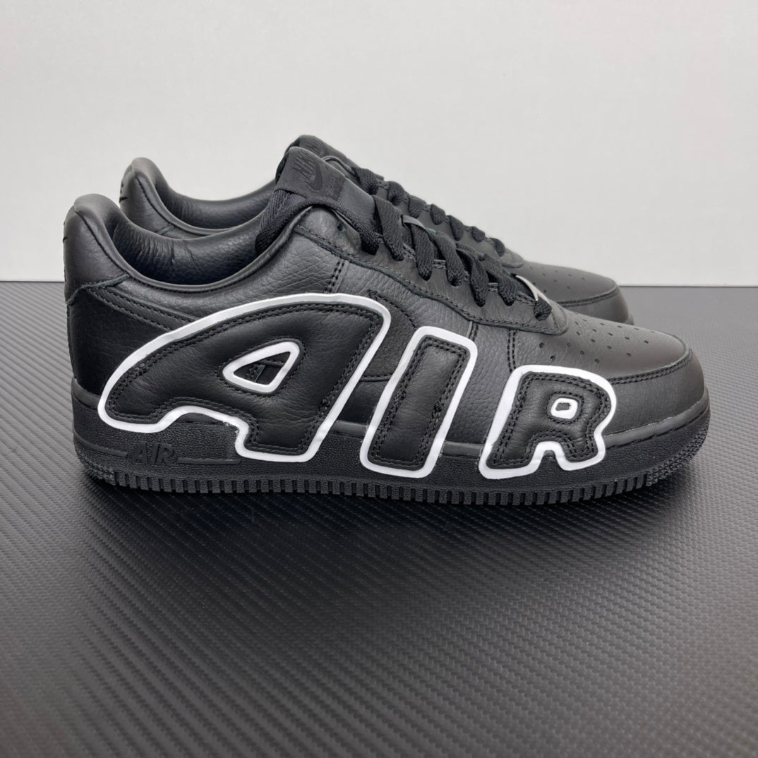 Black low-top sneakers with white flame-style logo overlays and black laces.
