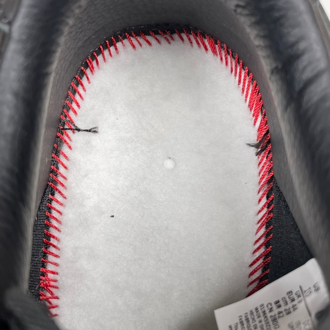 Sneaker interior with white lining and red contrast stitching, dark leather edge
