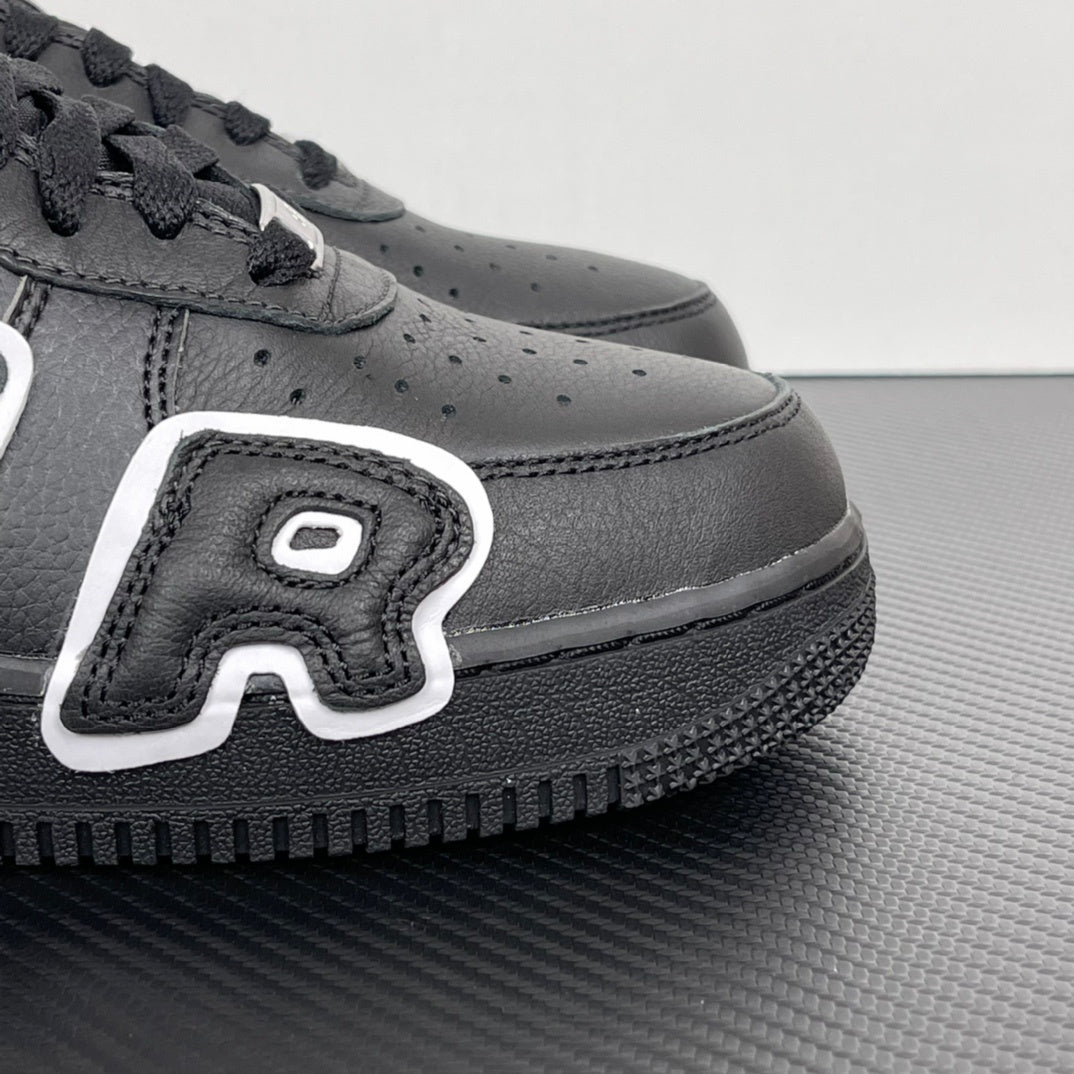 Black sneaker side panel with perforations, white logo patch, and textured sole.