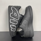 Black sneakers from side angle with white logo accents and black rubber toe cap.