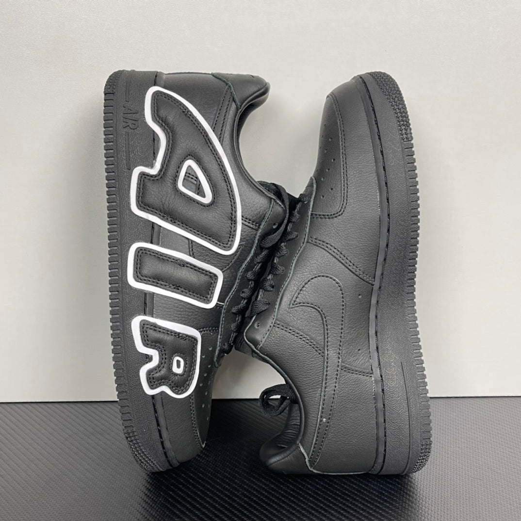 Black sneakers from side angle with white logo accents and black rubber toe cap.