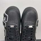 Black sneakers front view with perforated toe box and black lace-up front tabs.