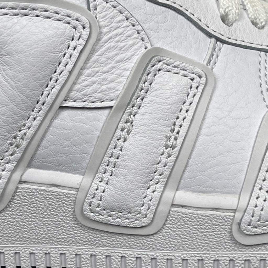 Close-up of white lace strap and stitched detailing on the sneaker upper.