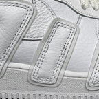 Close-up of white lace strap and stitched detailing on the sneaker upper.