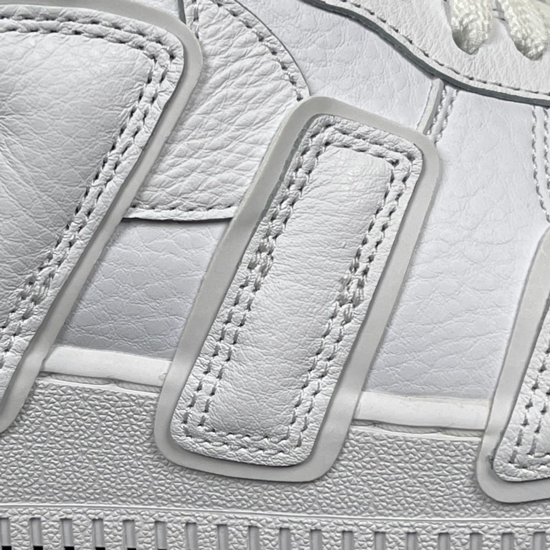 Close-up of white lace strap and stitched detailing on the sneaker upper.