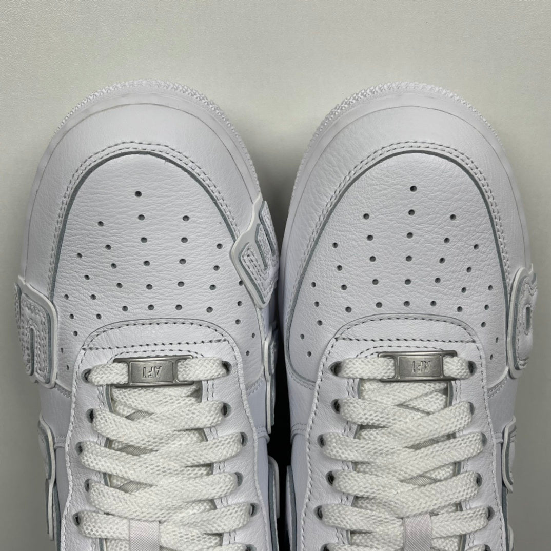 White leather sneaker toe boxes with perforations and lace-up tongues, front view.