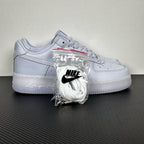 White leather low-top sneakers with Nike swoosh, lace-up, accessory bag attached