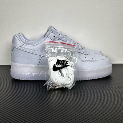 White leather low-top sneakers with Nike swoosh, lace-up, accessory bag attached