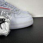 White leather low-top sneaker, Nike swoosh and lace eyelets, side view, bag