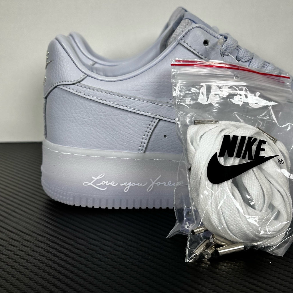 White leather low-top sneaker, Nike swoosh and lace-up front, with accessory bag