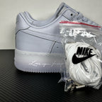 White leather low-top sneaker, Nike swoosh and lace-up front, with accessory bag