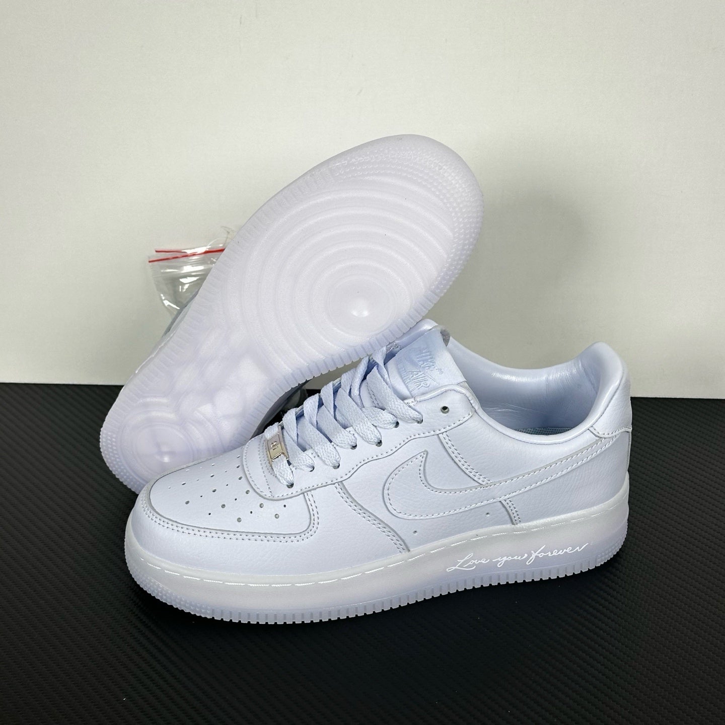 White leather low-top sneakers with textured rubber outsole, side and heel view