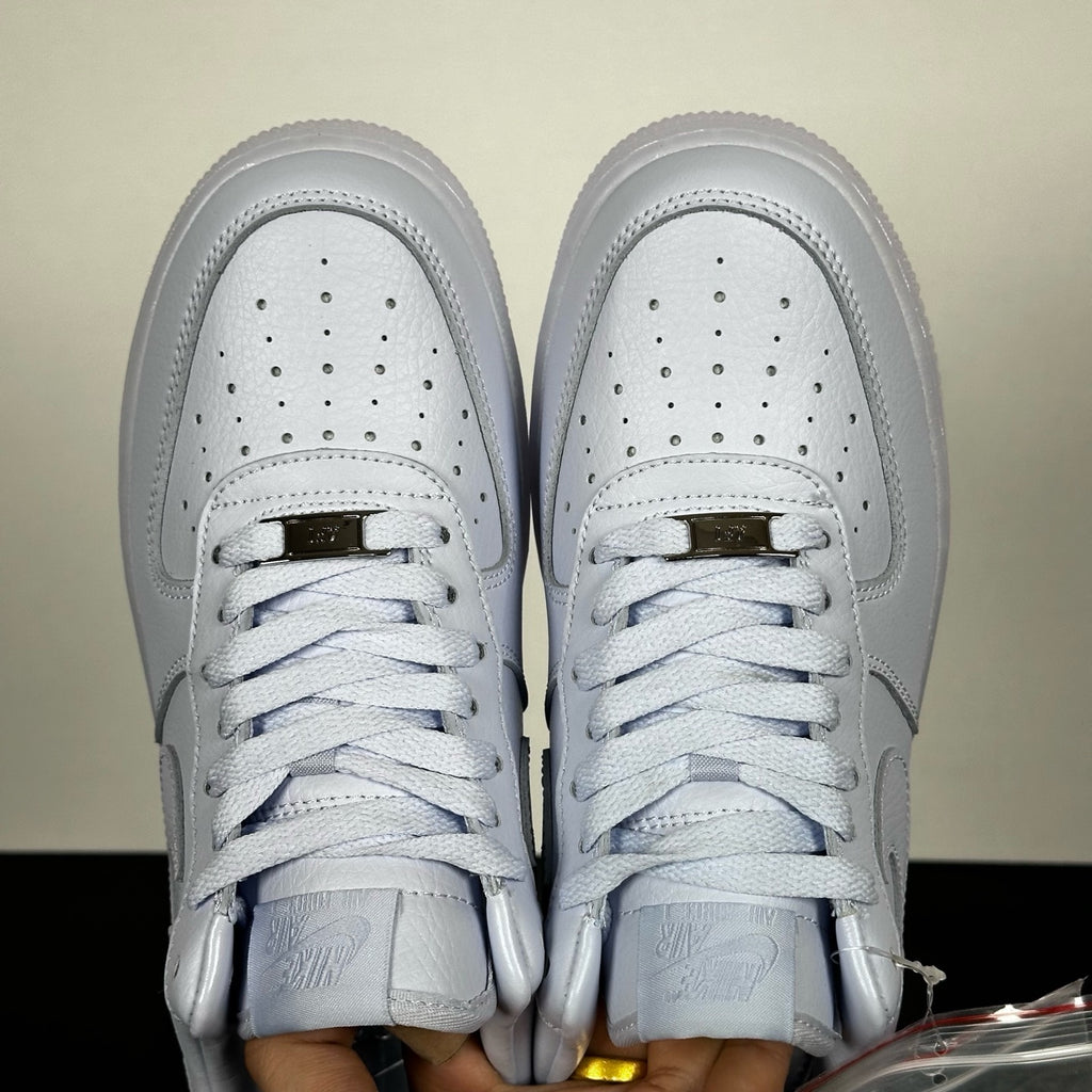 White leather low-top sneakers pair, perforated toe box and lace-up front
