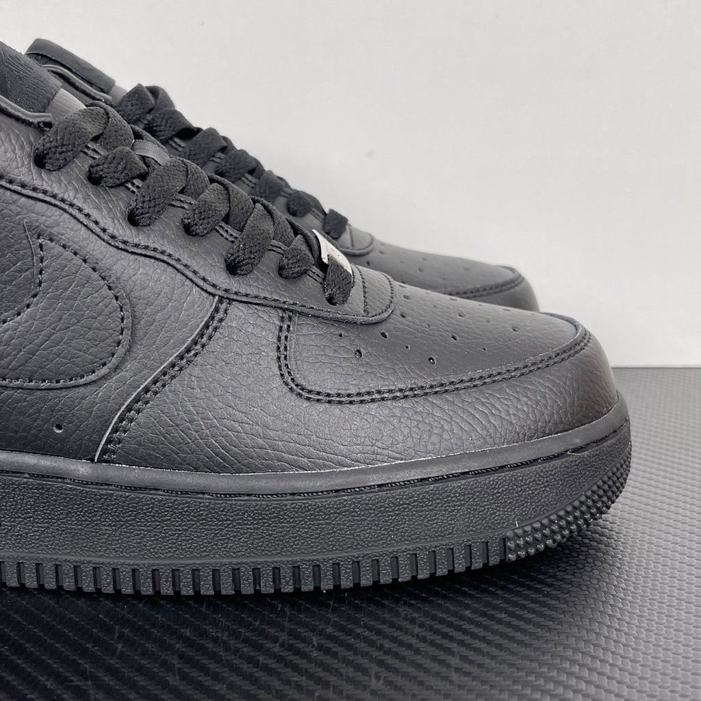 Air Force 1 sneaker side view in dark gray leather, lace-up with swoosh and stitch lines