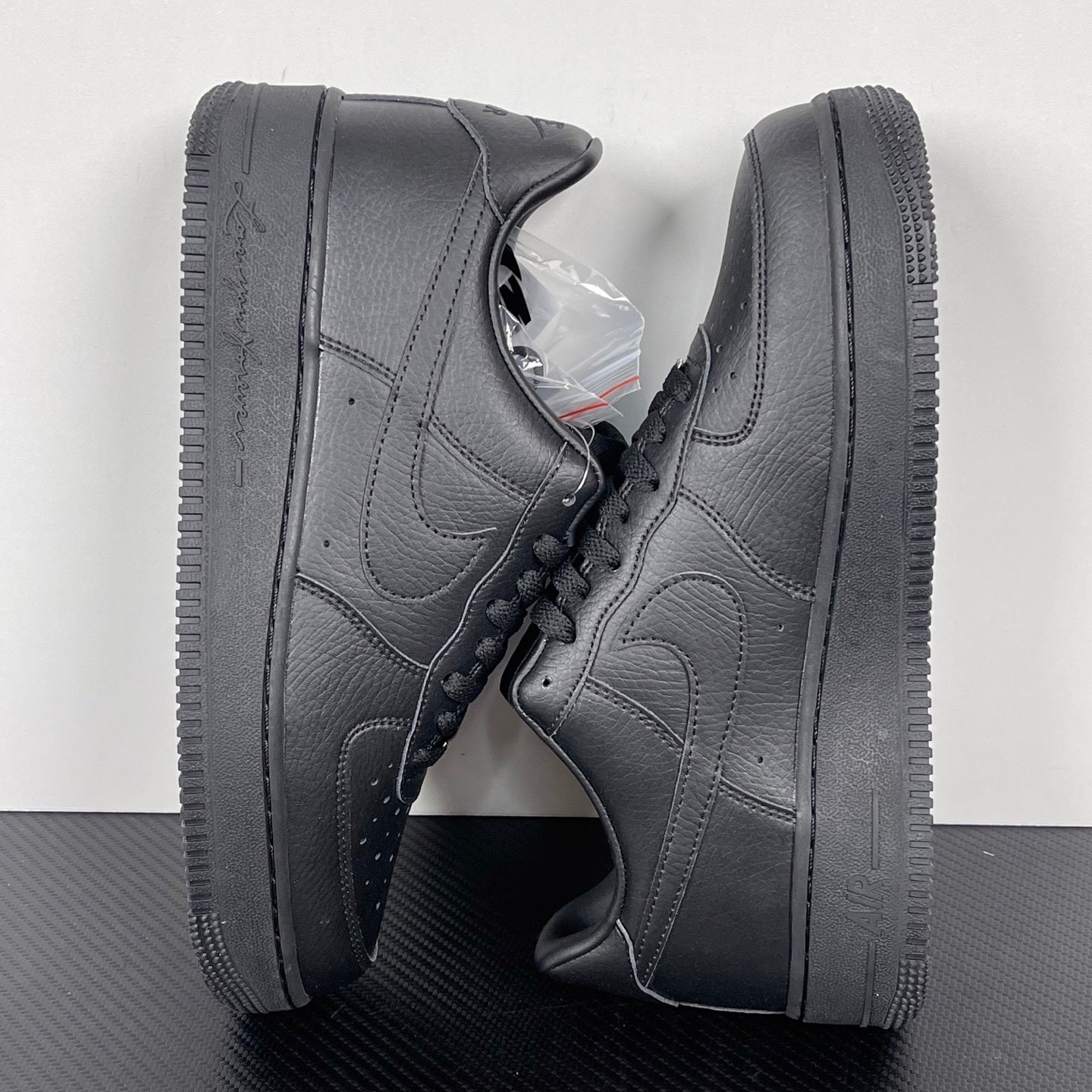 Air Force 1 sneakers angled view in dark gray leather, lace-up with swoosh and thick sole