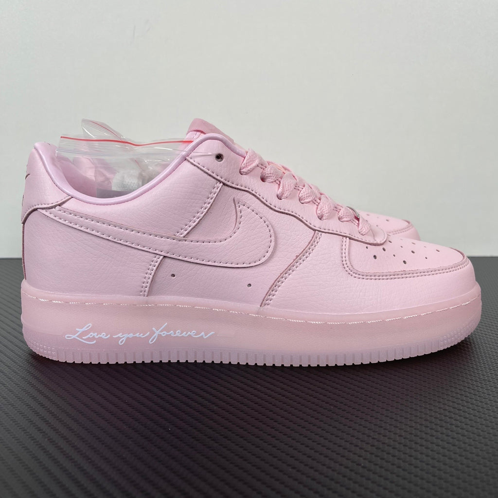 Pink low-top sneakers with white swoosh, lace-up front, perforated toe