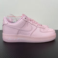 Pink low-top sneakers with white swoosh, lace-up front, perforated toe