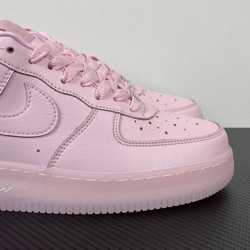 Pink low-top sneaker close-up with textured leather, swoosh and stitched panels