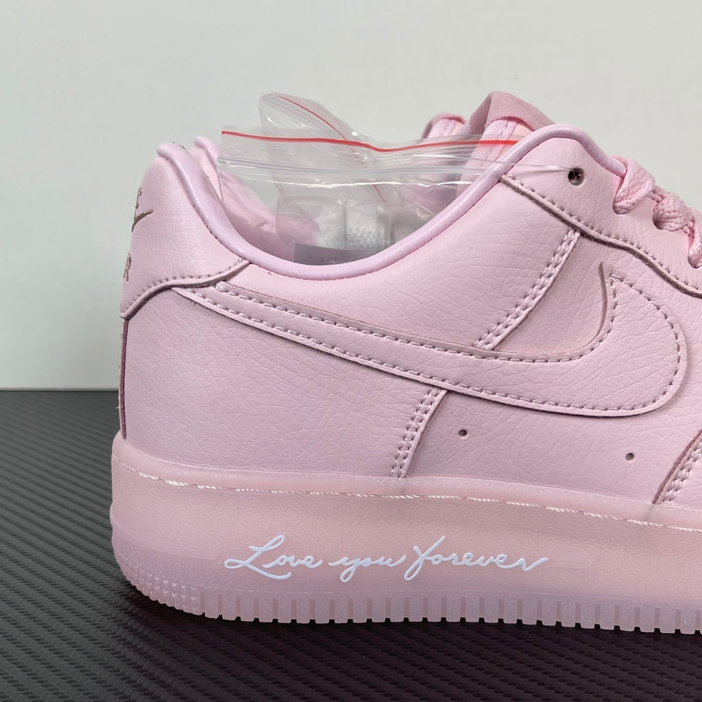 Pink low-top sneakers with lace-up front and large swoosh near midsole