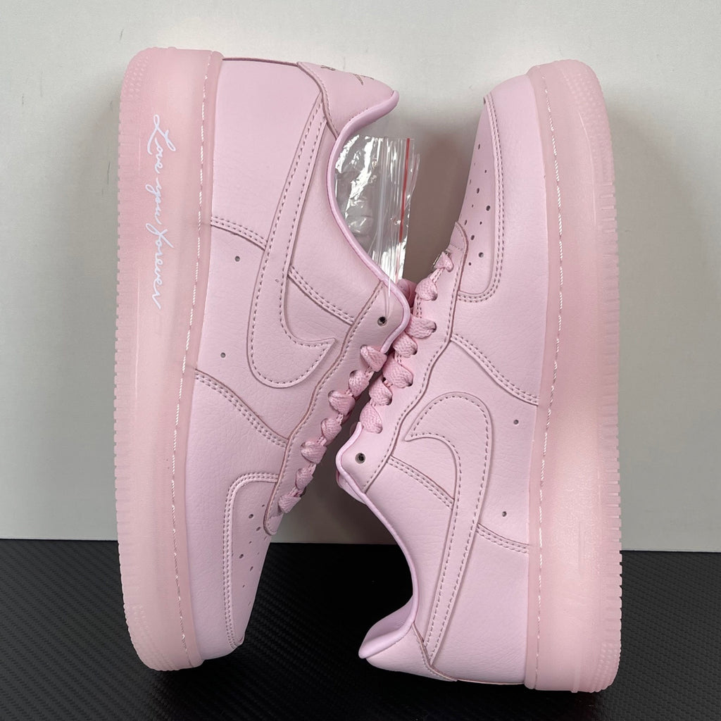 Pink low-top sneakers with lace-up front and swoosh on side