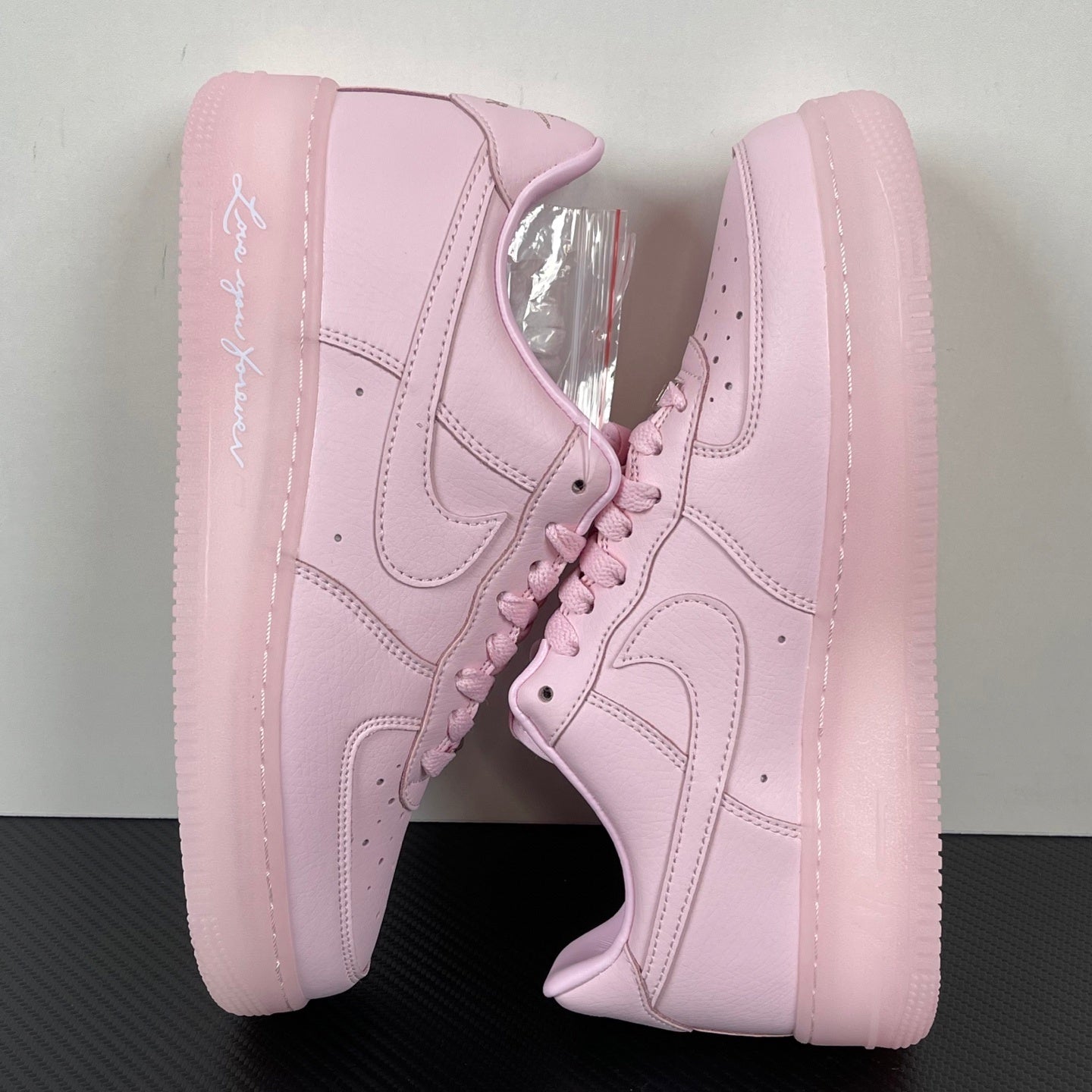 Pink low-top sneakers with lace-up front and swoosh on side