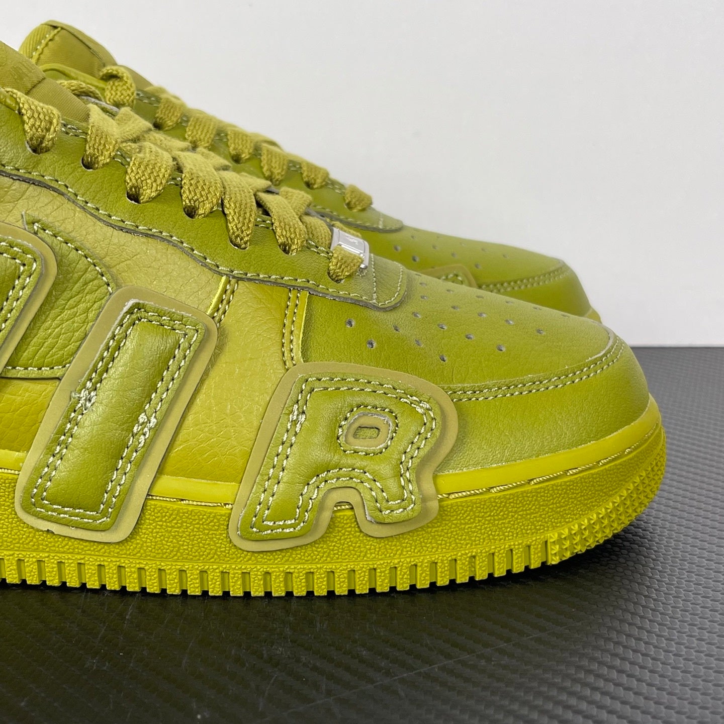 Lime green Air Force 1 sneaker with textured side logo detail and lace overlay stitching