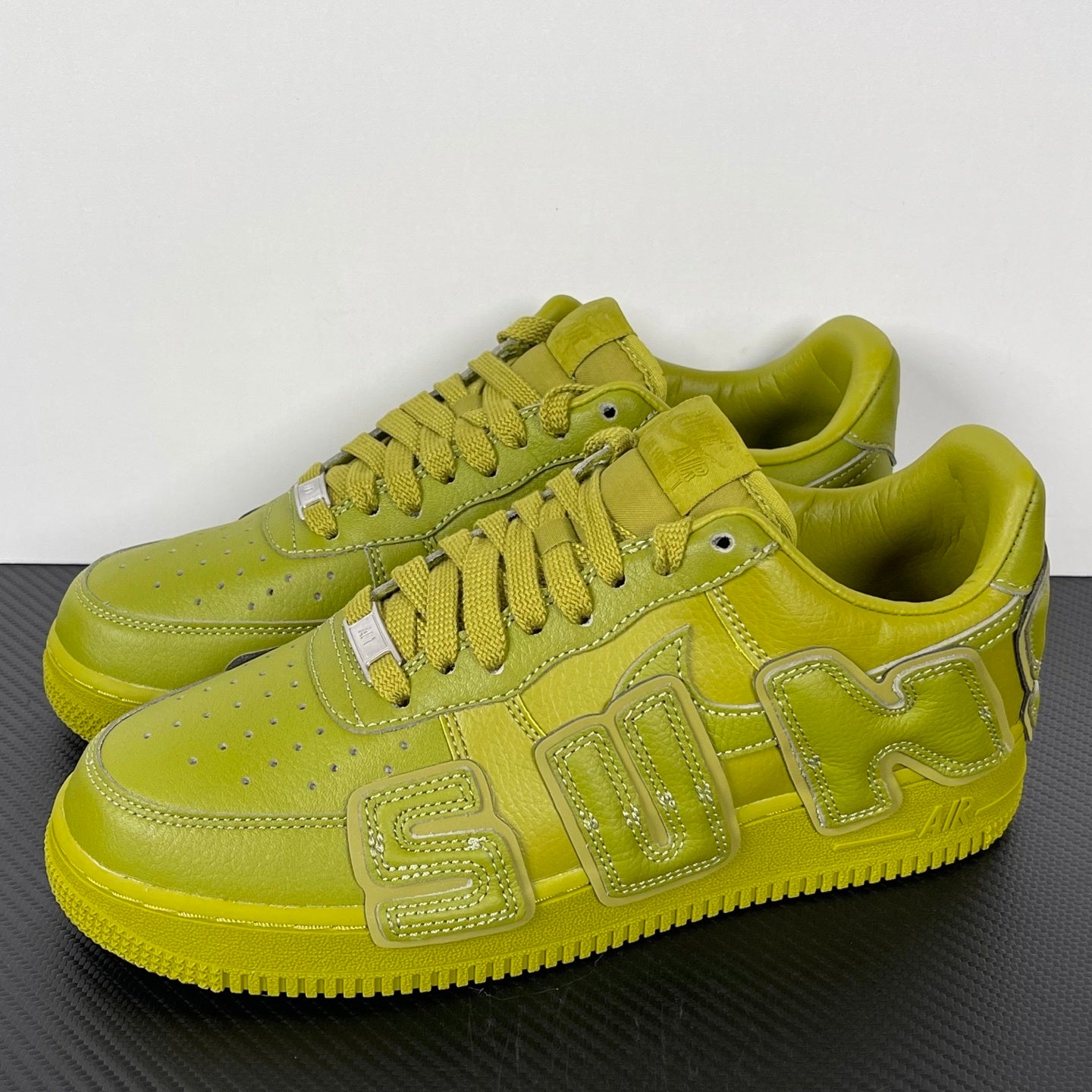 Lime green Air Force 1 sneakers, side view with lace-up front and stitched overlays