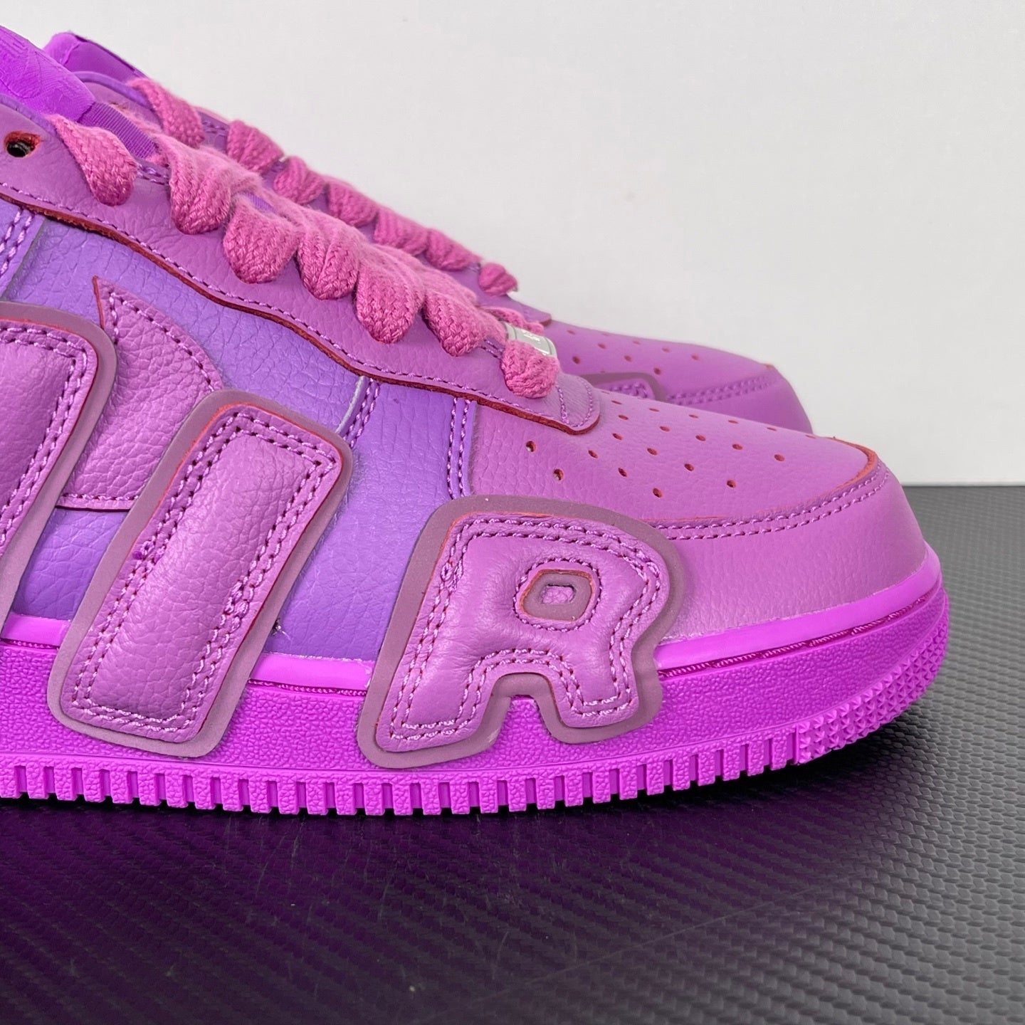 Purple Nike Air Force 1 sneakers, side view with pink laces and stitched panel