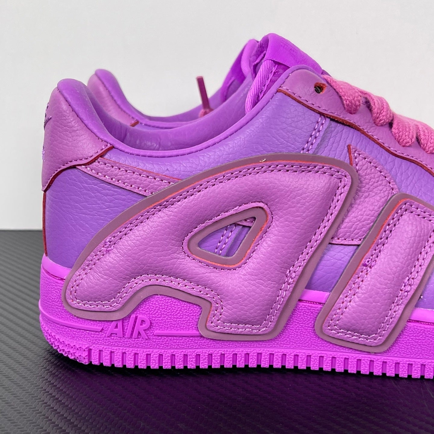 Purple Nike Air Force 1 sneakers, toe and side view with pink laces and large logo