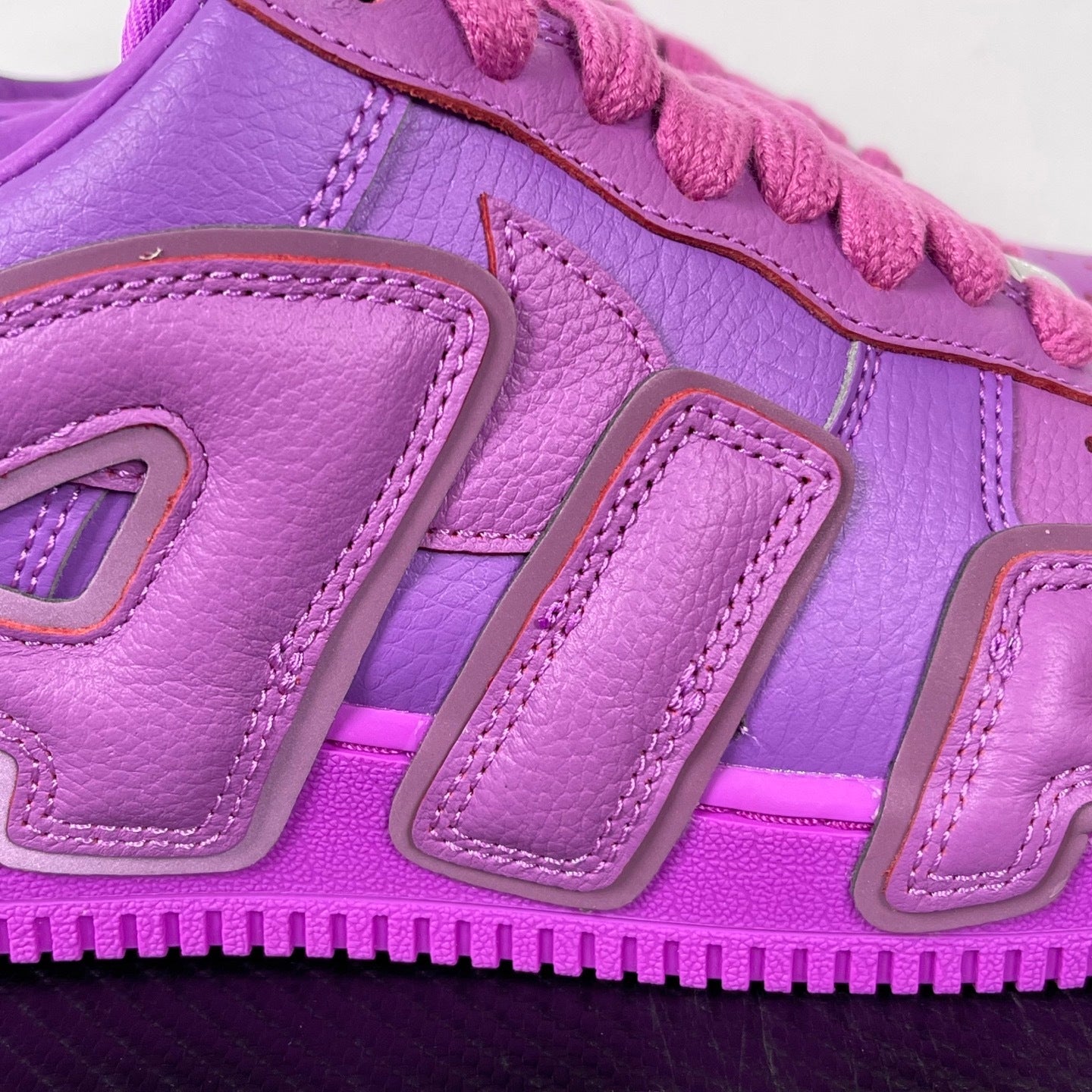 Purple Nike Air Force 1 sneakers, close-up of side panel and “AIR” logo