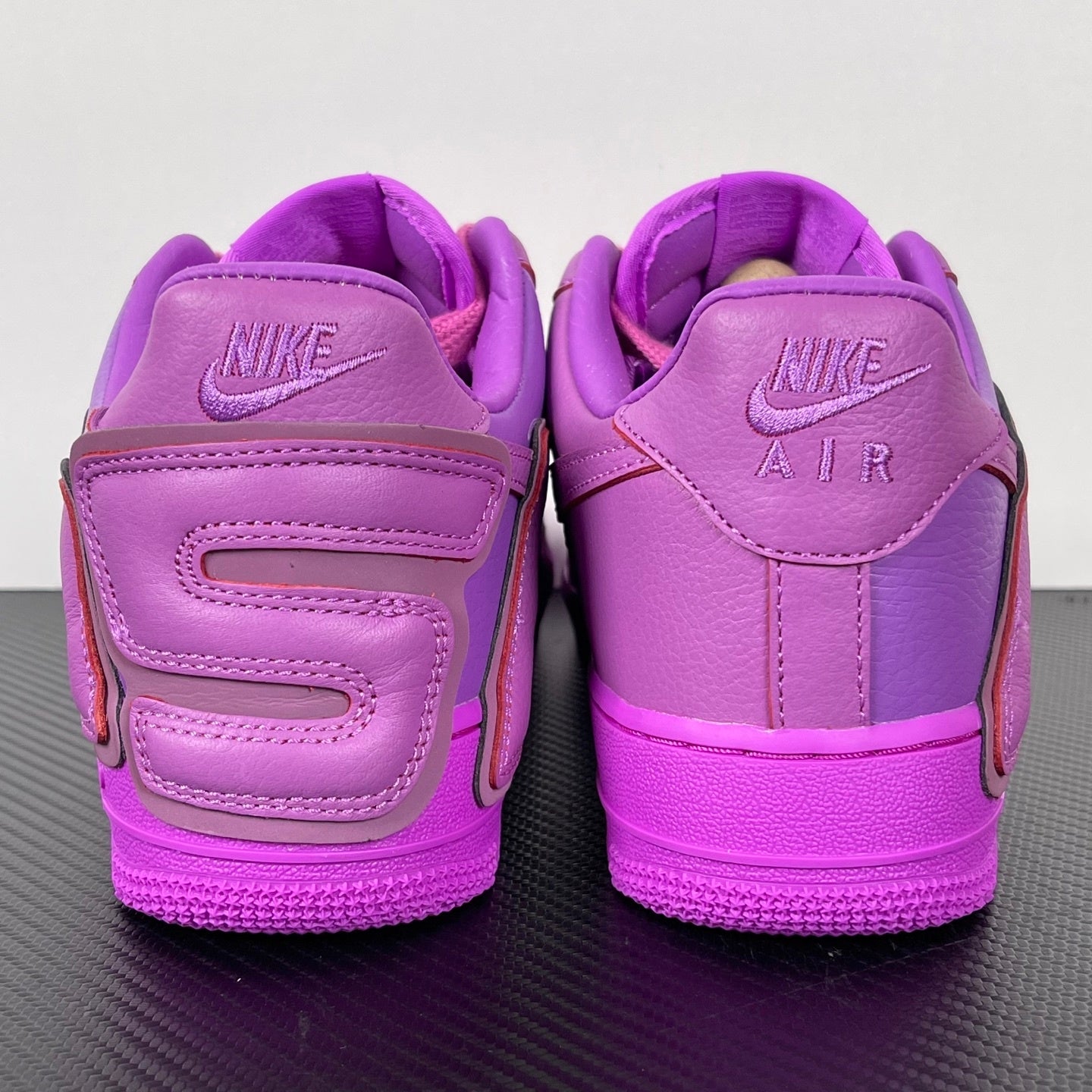 Purple Nike Air Force 1 sneakers, heel view with “NIKE AIR” embossing