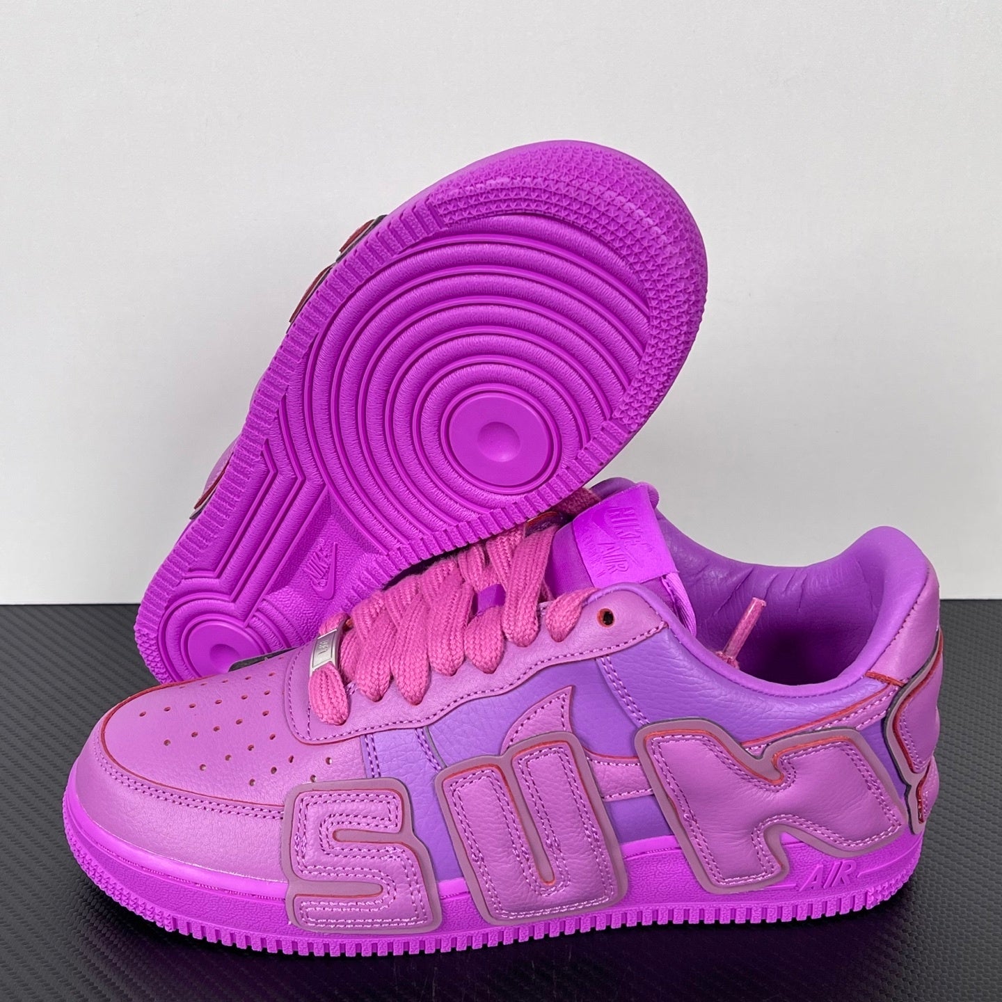Purple Nike Air Force 1 sneakers with pink laces, outsole and side view