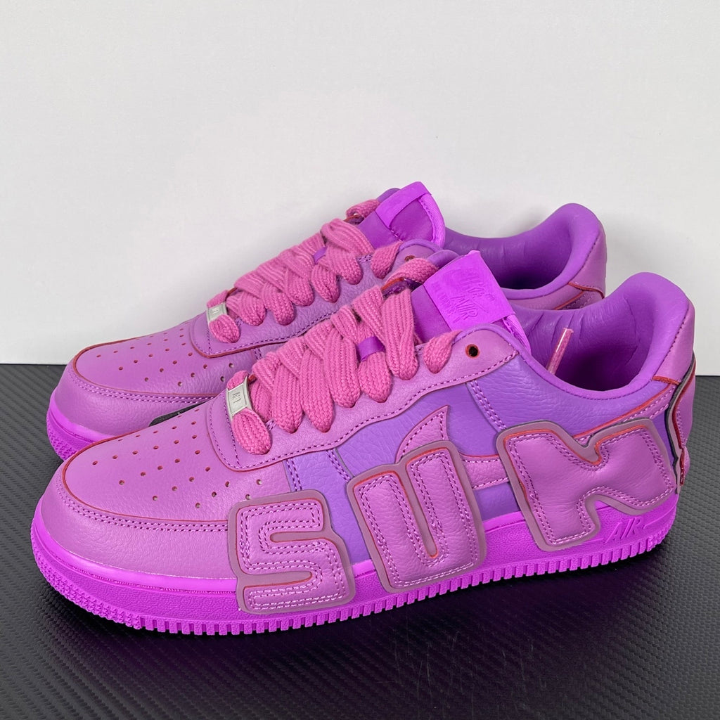 Purple Nike Air Force 1 sneakers, angled front view with pink laces